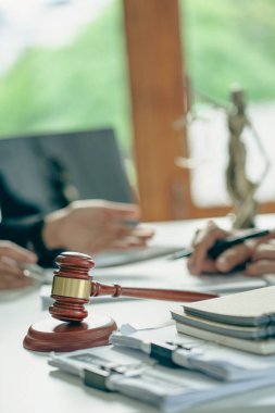 İş adamları ve avukatlar sözleşme belgelerini tartışıyor. Antlaşma Kanunu. İş sözleşmesi ve yasal belgeler ve yanında adalet terazisi ve çekiç bulunan ortak davalar hakkında bilgi edinin.