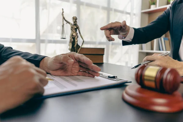 stock image Businessmen and lawyers discuss contract documents. Treaty Law. business contract and legal documents and study information about common court cases with the scales of justice and the hammer next to it.