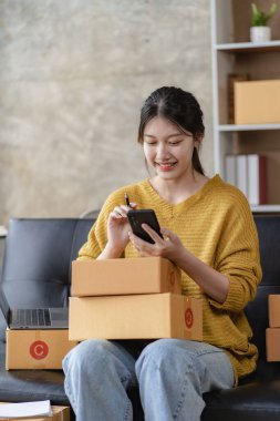 KOBİ Girişim Fikirleri, Genç Girişimciler evde üç akıllı telefon ve dizüstü bilgisayarla küçük işletme sahibi. Paketleme ve teslim durumu