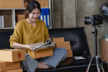 Genç girişimci küçük işletme sahibi ev ambalaj ve teslimat işinde çalışıyor Asyalı kadın KOBİ işletmecileri online alışveriş için dizüstü bilgisayarlar üzerinde çalışıyorlar. Neşeli ve mutlu KOBİ başlangıç iş fikri