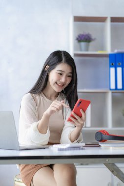 Kırmızı kablosuz kulaklık takan Asyalı kız öğrenci çevrimiçi öğrenim konsepti