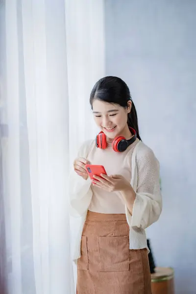 Asiatique Étudiante Tenant Cou Smartphone Rouge Portant Casque Sans Fil — Photo