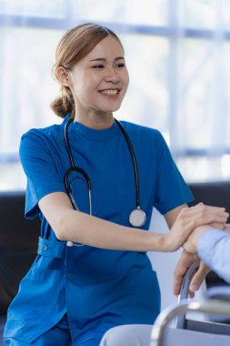 Asyalı kadın doktor, erkek hasta danışman doktorla konuşuyor. Sonuçları muayenehanede açıkça aldığını söylüyor.