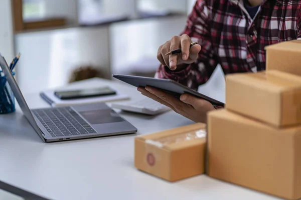 stock image SME Business Entrepreneur Working From Home With Parcel Boxes And Laptop Taking Orders And Shipping Online Grocery Business Ideas