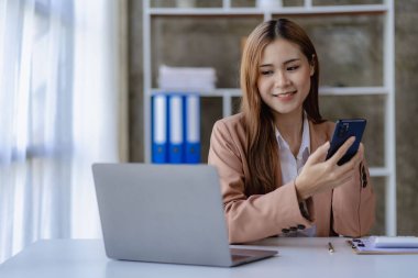 Ofis masasında dizüstü bilgisayarla çalışan Asyalı güzel bir iş kadını. Finansal belgeleri yazan bir girişimci kadın. İşteki e-postayı kontrol et Finansal muhasebe kavramı.