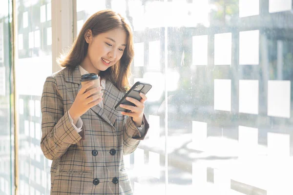 Excited Asian woman talking on the phone in a dating app. Closeup happy joyful feeling reading good news on phone