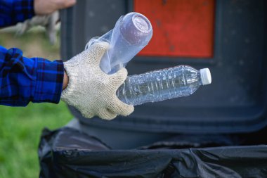 Genç bir adam plastik şişeleri ve siyah poşetleri topluyor ve onları geri dönüşüm için toplayanlara satmak üzere biraraya getiriyor. Atık ayırma ve çevre koruma kavramı