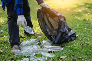 Genç bir adam plastik şişeleri ve siyah poşetleri topluyor ve onları geri dönüşüm için toplayanlara satmak üzere biraraya getiriyor. Atık ayırma ve çevre koruma kavramı
