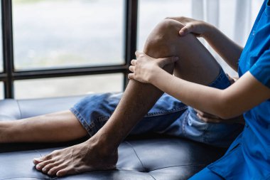 Fizyoterapist. Genç adamın yaralı dizini tedavi eden kadın terapist. Fiziksel rehabilitasyon, fizik tedavi konsepti.,