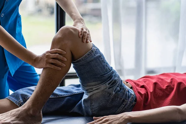 Fysiotherapeut Vrouwelijke Therapeut Die Gewonde Knie Van Een Jonge Man — Stockfoto