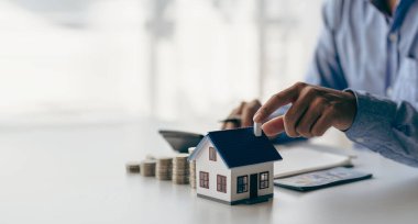 Banka kriterlerini karşılamak için yeni bir ev almadan önce kontrol listesi. Yakın plan gümüş para teslimatı ve ev modeli Tasarrufları fütüristik bir konsept içinde paranızı emlak sahibine ekleyerek.