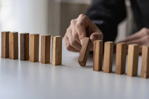 stock image Businessman hand pulling stacked wooden blocks on the table business planning Risk Management, Solutions and Strategies