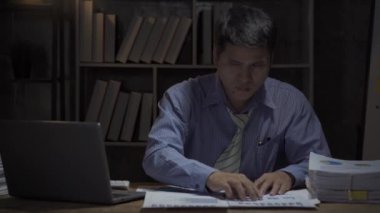 İşadamı, bir masaüstü bilgisayarıyla fazla mesai yaptığını ve ofiste geç saatlere kadar ücretsiz olmayan belgeleri topladığını vurguladı. İş adamları fazla mesai yapar.