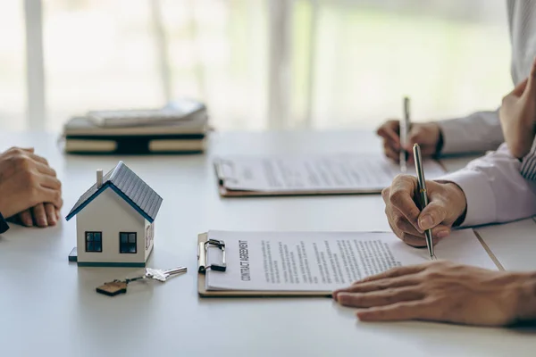 부동산 중개업자는 주택을 매입하기 조건에 논의한다 고객에게 계약서에 서명할 — 스톡 사진