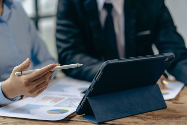 İşletme danışmanları finansal işletmelerin, muhasebe, sözleşmelerin, yatırım danışmanlık şirketlerinin pazarlama planlarının tablet ve teknoloji kullanarak nasıl ilerlediğini gösteren mali rakamları analiz ederler..
