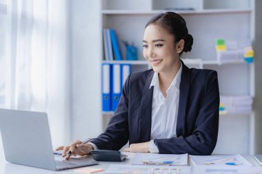 Ekonomik konsept Asyalı kadın muhasebeci veya banka hesapları hesaplayan bankacı. İşteki genç Asyalı iş kadını. Belgeler, vergiler, analiz raporları, tasarruf ve finans.