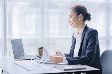 Ekonomik konsept Asyalı kadın muhasebeci veya banka hesapları hesaplayan bankacı. İşteki genç Asyalı iş kadını. Belgeler, vergiler, analiz raporları, tasarruf ve finans.