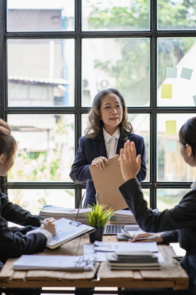 Çeşitli iş kadınları liderleri ofis konferans odasında Asyalı iş kadını resmi toplantıda personele konuşuyor. Çeşitli müşteri ortakları, üst düzey yönetici takım liderlerini dinliyor..