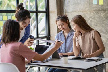 Bir grup genç iş adamı, finansal grafik ve dizüstü bilgisayarlı modern ofiste yeni bir iş kurma konusunda fikir alışverişinde bulunuyorlar.