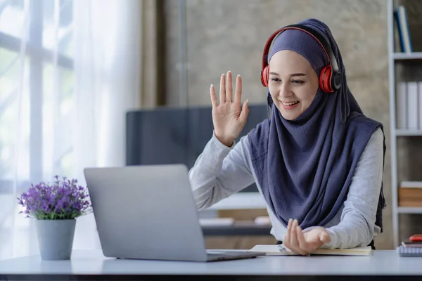 stock image Muslim female student in hijab studying online with laptop Asian girl in headphones doing homework with digital tablet teaching online Muslim female teacher is making a video call.