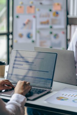 Dikey görünüm işadamı elinde bir kalem tutarak hesap makinesiyle çizelgelerle çalışır ve iş stratejilerini analiz eder. finansal istatistikler