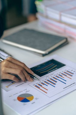 Dikey görünüm işadamı elinde bir kalem tutarak hesap makinesiyle çizelgelerle çalışır ve iş stratejilerini analiz eder. finansal istatistikler