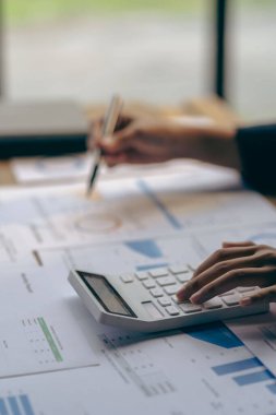 Dikey görünüm işadamı elinde bir kalem tutarak hesap makinesiyle çizelgelerle çalışır ve iş stratejilerini analiz eder. finansal istatistikler