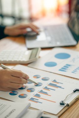 Dikey görünüm işadamı elinde bir kalem tutarak hesap makinesiyle çizelgelerle çalışır ve iş stratejilerini analiz eder. finansal istatistikler