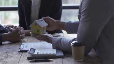 Emlakçı, ev anahtarı, ev sigortası konsepti, aile sigortası, kira indirimi videosu olan evleri gösteriyor.
