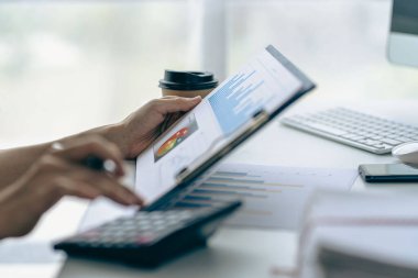 Ofiste mali belgeleri, bilgisayarı ve hesap makinesiyle çalışan genç işadamı mali raporları, yatırım hesaplama konseptini analiz etmeyi planlıyor.