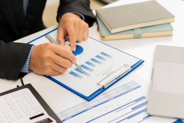 Ofiste mali belgeleri, bilgisayarı ve hesap makinesiyle çalışan genç işadamı mali raporları, yatırım hesaplama konseptini analiz etmeyi planlıyor.