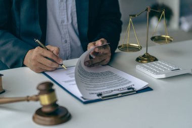 Hakimin çekiç ve altın pullarıyla çalışan avukatlık bürosu terazili Adalet heykeli ve belge üzerinde çalışan avukatlık danışmanlık ve adalet kavramı