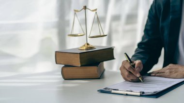 Hakimin çekiç ve altın pullarıyla çalışan avukatlık bürosu terazili Adalet heykeli ve belge üzerinde çalışan avukatlık danışmanlık ve adalet kavramı