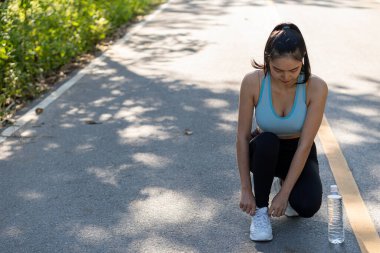 Parkta egzersiz yapan, koşan, plajda gezen Asyalı genç bir kadının görüntüsü. Açık hava fitness modelleriyle forma gir..