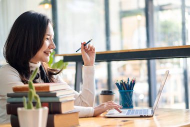 Öğrenci ve çevrimiçi çalışma masası Laptop bilgisayar ve cep telefonuyla üniversite öğrencilerinin kahve dükkanlarındaki yaşam tarzı.