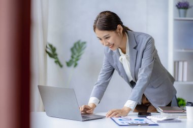 Dizüstü bilgisayar ve finans üzerine çalışan genç Asyalı kadın muhasebeci, serbest iş, çevrimiçi pazarlama, e-ticaret pazarlama konsepti.