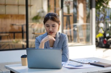 Dizüstü bilgisayar ve finans üzerine çalışan genç Asyalı kadın muhasebeci, serbest iş, çevrimiçi pazarlama, e-ticaret pazarlama konsepti.
