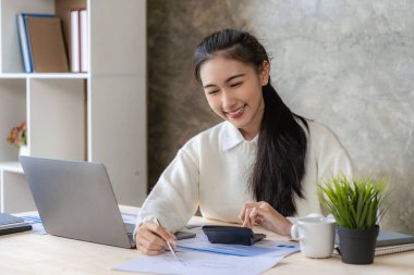 Dizüstü bilgisayar ve finans üzerine çalışan genç Asyalı kadın muhasebeci, serbest iş, çevrimiçi pazarlama, e-ticaret pazarlama konsepti.