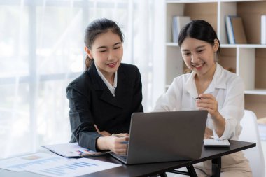 Laptop bilgisayarı ve iş yerinde finans üzerine çalışan iki genç Asyalı muhasebeci. Serbest meslek işte. Çevrimiçi pazarlama. ekommerce pazarlama fikirleri