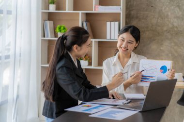 Laptop bilgisayarı ve iş yerinde finans üzerine çalışan iki genç Asyalı muhasebeci. Serbest meslek işte. Çevrimiçi pazarlama. ekommerce pazarlama fikirleri