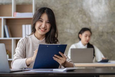 Laptop bilgisayarı ve iş yerinde finans üzerine çalışan iki genç Asyalı muhasebeci. Serbest meslek işte. Çevrimiçi pazarlama. ekommerce pazarlama fikirleri