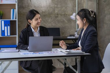 Laptop bilgisayarı ve iş yerinde finans üzerine çalışan iki genç Asyalı muhasebeci. Serbest meslek işte. Çevrimiçi pazarlama. ekommerce pazarlama fikirleri