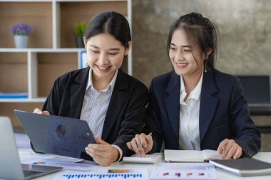 Laptop bilgisayarı ve iş yerinde finans üzerine çalışan iki genç Asyalı muhasebeci. Serbest meslek işte. Çevrimiçi pazarlama. ekommerce pazarlama fikirleri