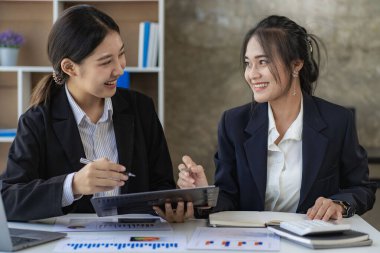 Laptop bilgisayarı ve iş yerinde finans üzerine çalışan iki genç Asyalı muhasebeci. Serbest meslek işte. Çevrimiçi pazarlama. ekommerce pazarlama fikirleri