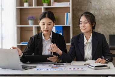 Laptop bilgisayarı ve iş yerinde finans üzerine çalışan iki genç Asyalı muhasebeci. Serbest meslek işte. Çevrimiçi pazarlama. ekommerce pazarlama fikirleri