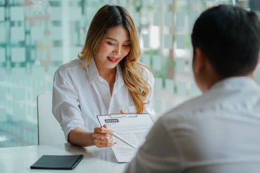 İş başvurusu için işverenine özgeçmiş veren genç bir adam. Konsept, şirketin iş pozisyonları ve çalışanlar üzerinde mutabakat sağlayabildiğini gösteriyor..