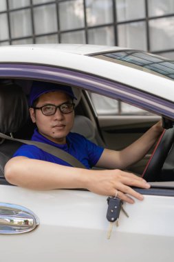 Yakışıklı genç adam elinde yeni bir arabanın anahtarlarını tutarken gülümseyen, elinde araba anahtarlarıyla Asyalı bir adam yeni bir araba alıp satma fikri....