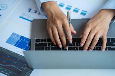 Rapor çizelgesiyle dizüstü bilgisayarda yazan işadamı, analiz grafiği grafiği, gelir ve gider vergisi kredi kartı fatura finans kavramını hesaplamak için hesap makinesine baskı yapıyor.