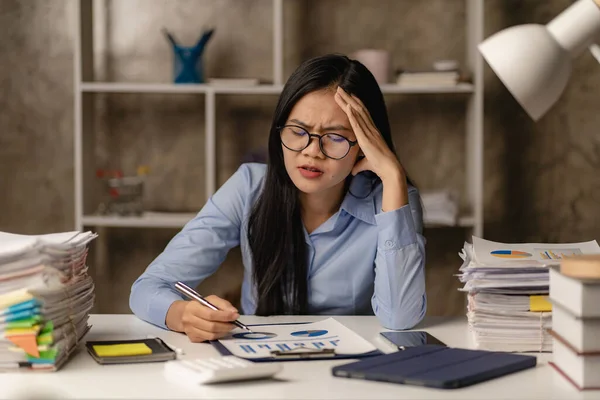 アジアの女性会計士は 書類を緩くし 頭の上に手をつないで残業を強調女性が心配し オフィスでのハードワークで強調 — ストック写真