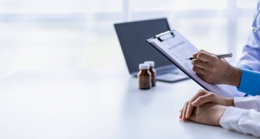 Kadın jinekolojik hastalıklarına danışmanlık yapan, reçeteli pano notları yazan, klinikteki hastaları dinleyen psikiyatrist..